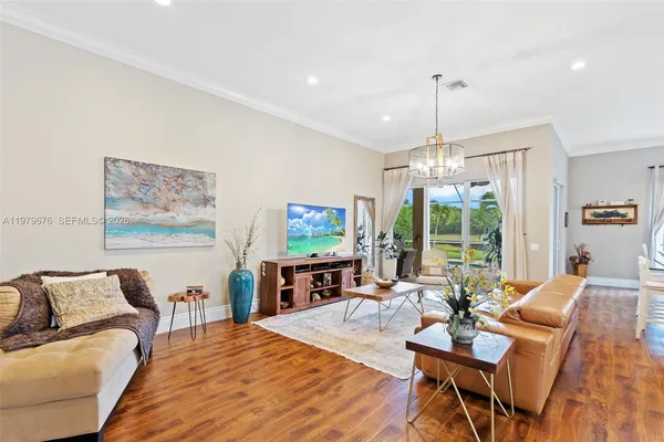 a living room with furniture a flat screen tv and a large window