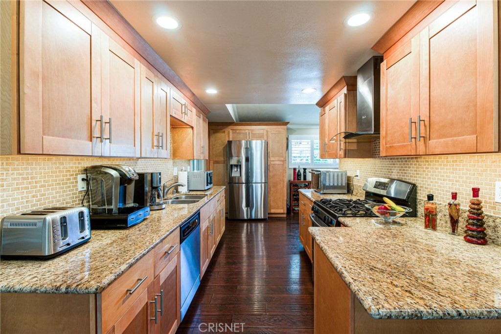 a kitchen with granite countertop lots of counter top space a sink a stove and cabinets