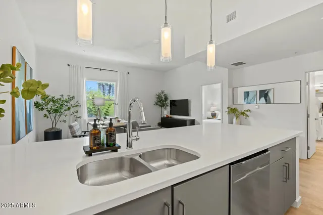 a kitchen with stainless steel appliances a dining table chairs and refrigerator