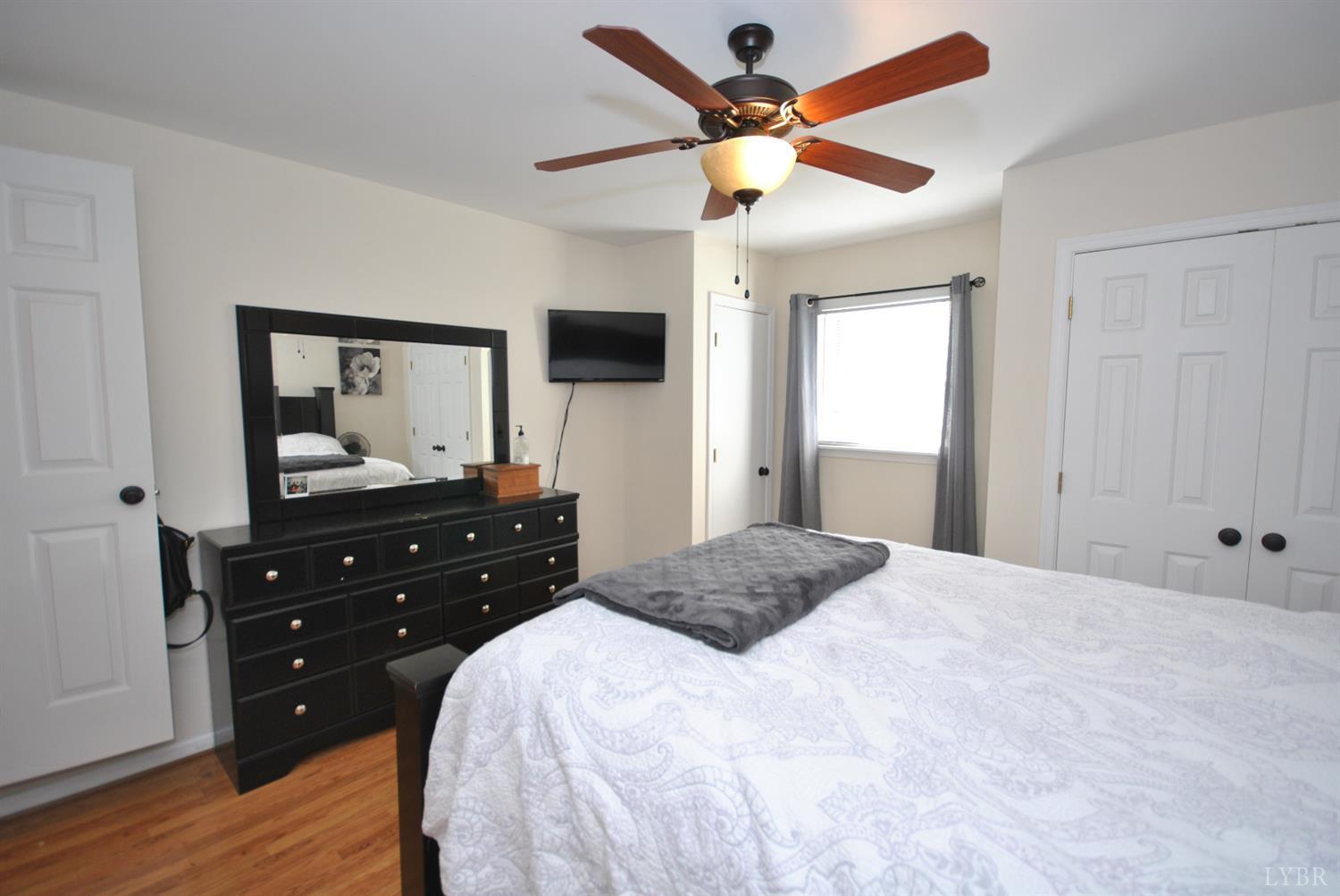 3350 Roaring Run Road Goode, VA 24556 - Photo 68 of 90 a bedroom with a bed and a flat tv screen on dresser