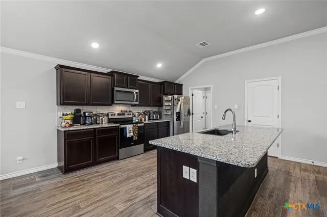 a kitchen with stainless steel appliances granite countertop a stove a sink and a refrigerator