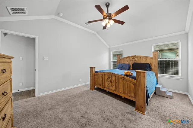 a bed sitting in a bedroom next to a window and a chandelier