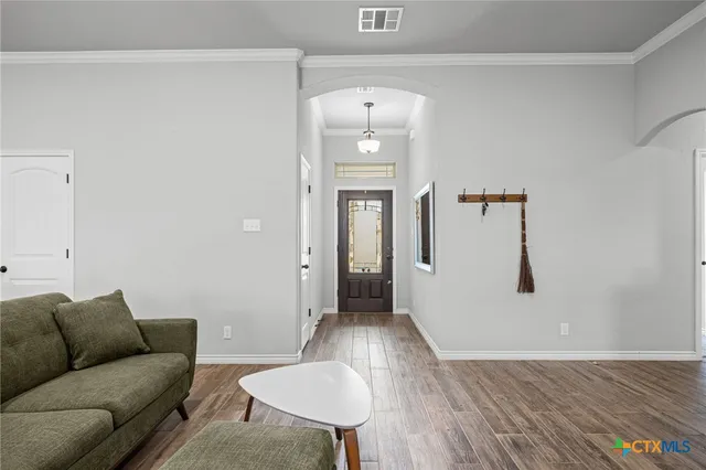 a living room with furniture and a wooden floor