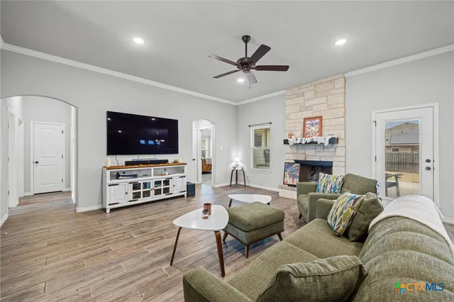 a living room with furniture a flat screen tv and a fireplace