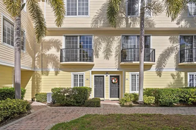 a front view of a house with a yard and potted plants