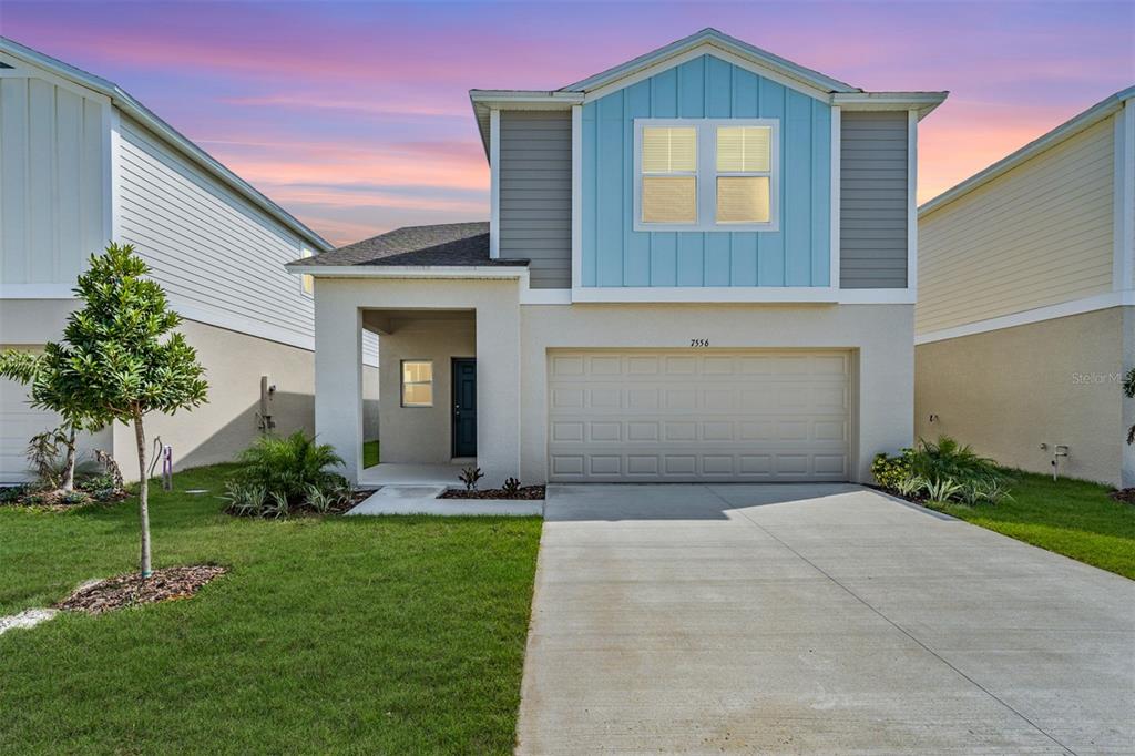 a front view of a house with a yard and garage