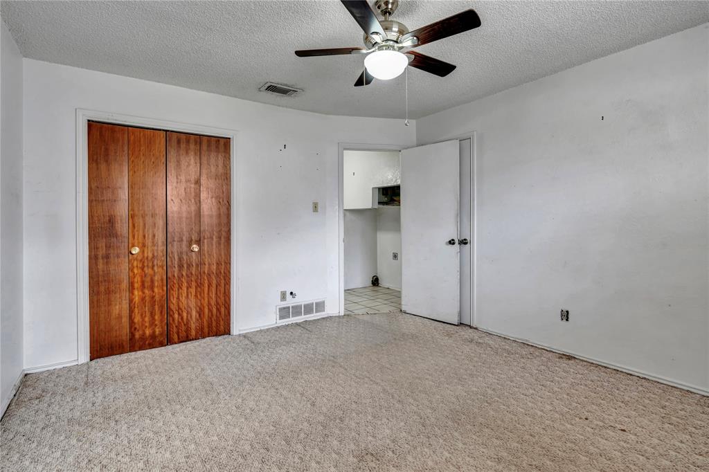 210 Slaughter Street Arlington, TX 76011 - Photo 12 of 33 Unfurnished bedroom featuring a textured ceiling, a closet, light carpet, and a ceiling fan