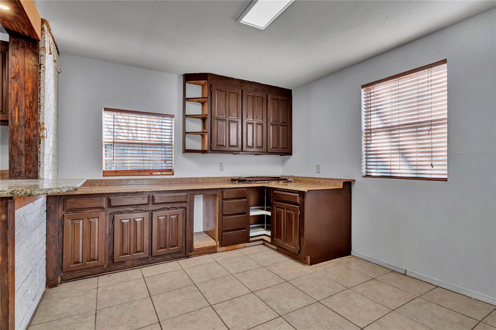 210 Slaughter Street Arlington, TX 76011 - Photo 16 of 33 Kitchen featuring open shelves, light countertops, and light tile patterned flooring