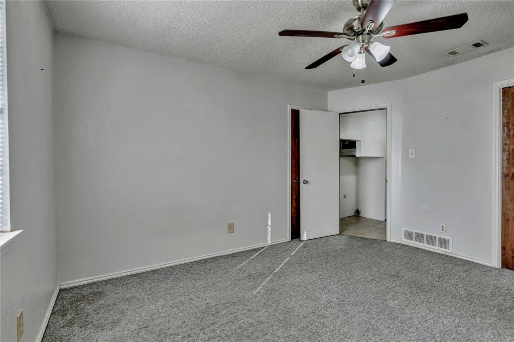 210 Slaughter Street Arlington, TX 76011 - Photo 28 of 33 Unfurnished bedroom featuring carpet flooring, a textured ceiling, a ceiling fan, and a closet