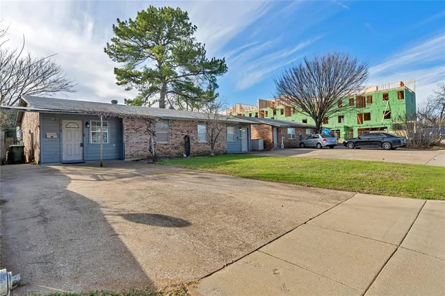 a view of a house with a yard and potted plants