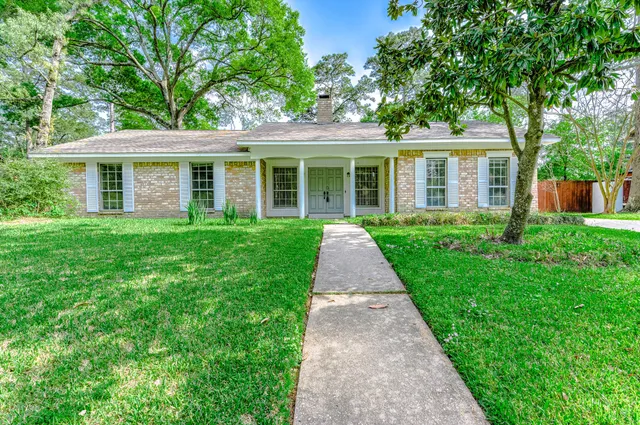 a front view of a house with a yard and potted plants