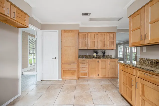 a kitchen with granite countertop a stove a sink and a refrigerator