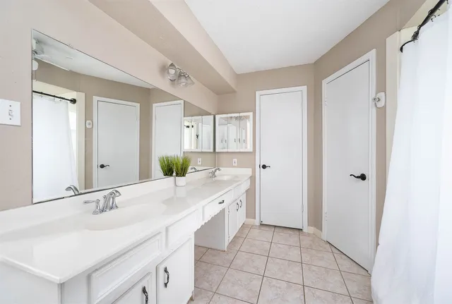 a spacious bathroom with a double vanity sink and a mirror