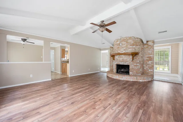 a view of empty room with wooden floor and fireplace