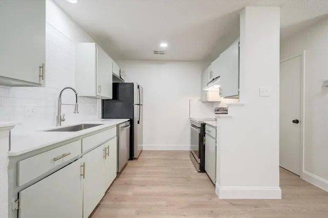 a kitchen with a sink stove and refrigerator