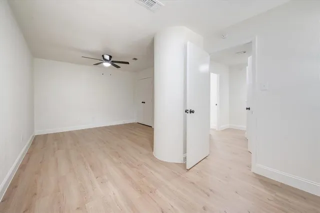 an empty room with a mirror and a wooden floor