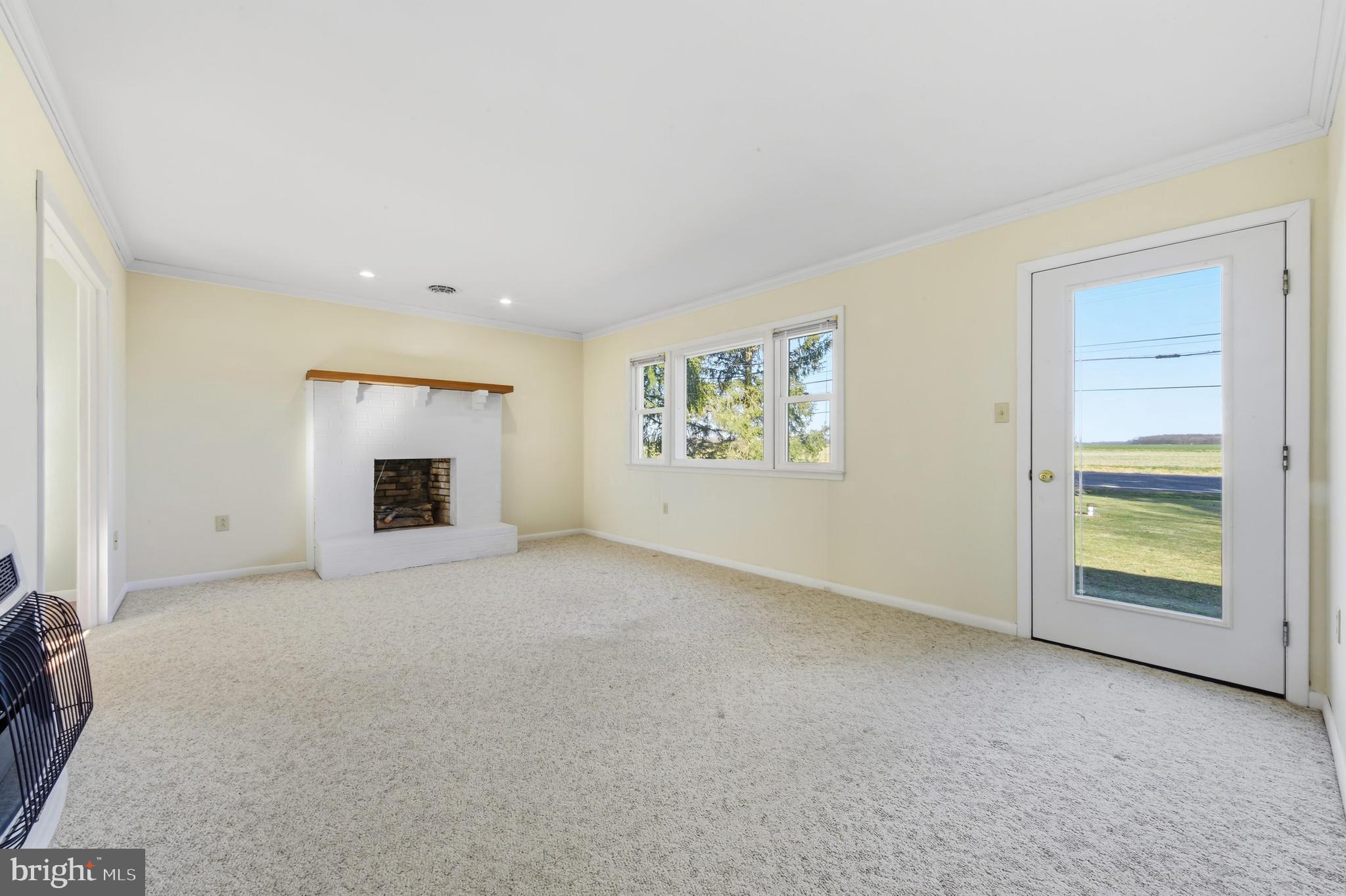 24339 Chestertown Road Chestertown, MD 21620 - Photo 15 of 35 an empty room with furniture and a fireplace