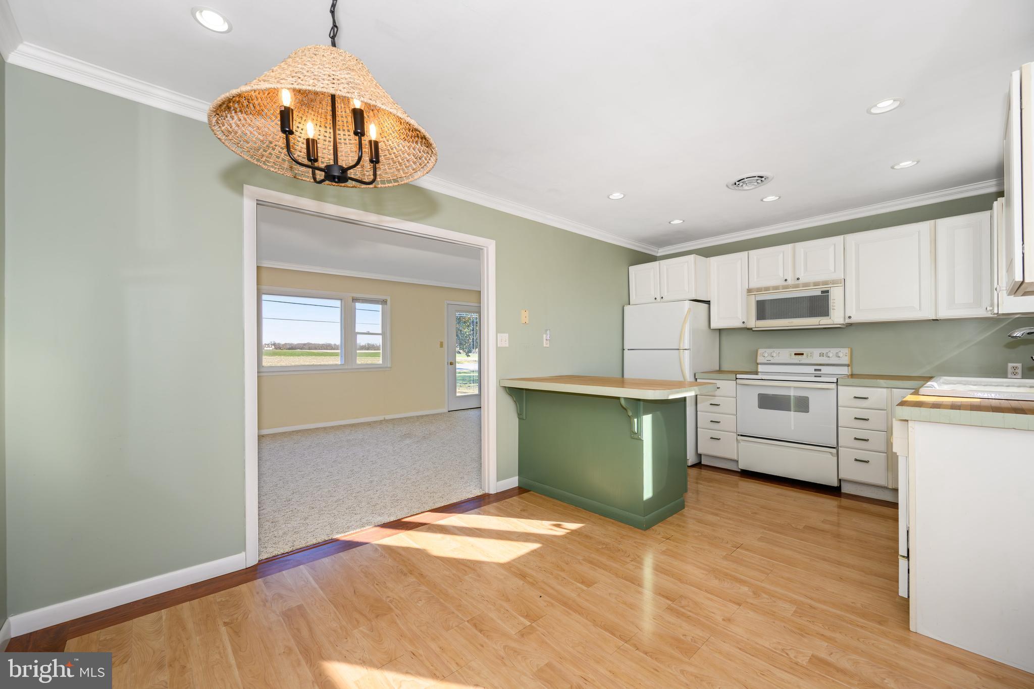 24339 Chestertown Road Chestertown, MD 21620 - Photo 10 of 35 a kitchen with a refrigerator and a stove top oven