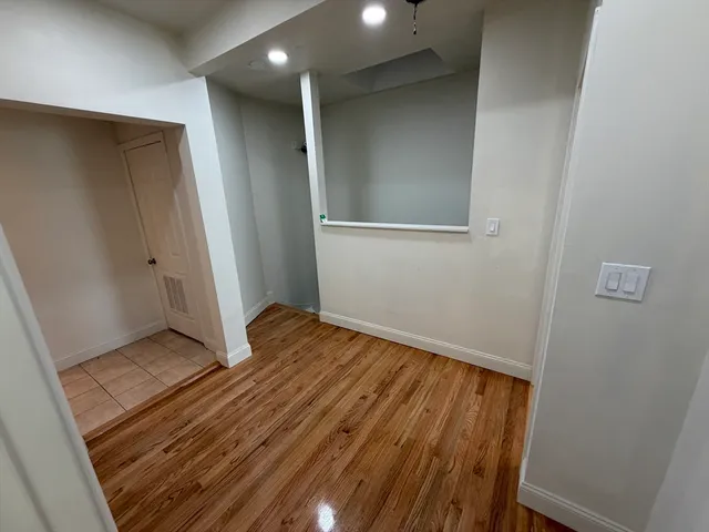 a view of an empty room with wooden floor and closet