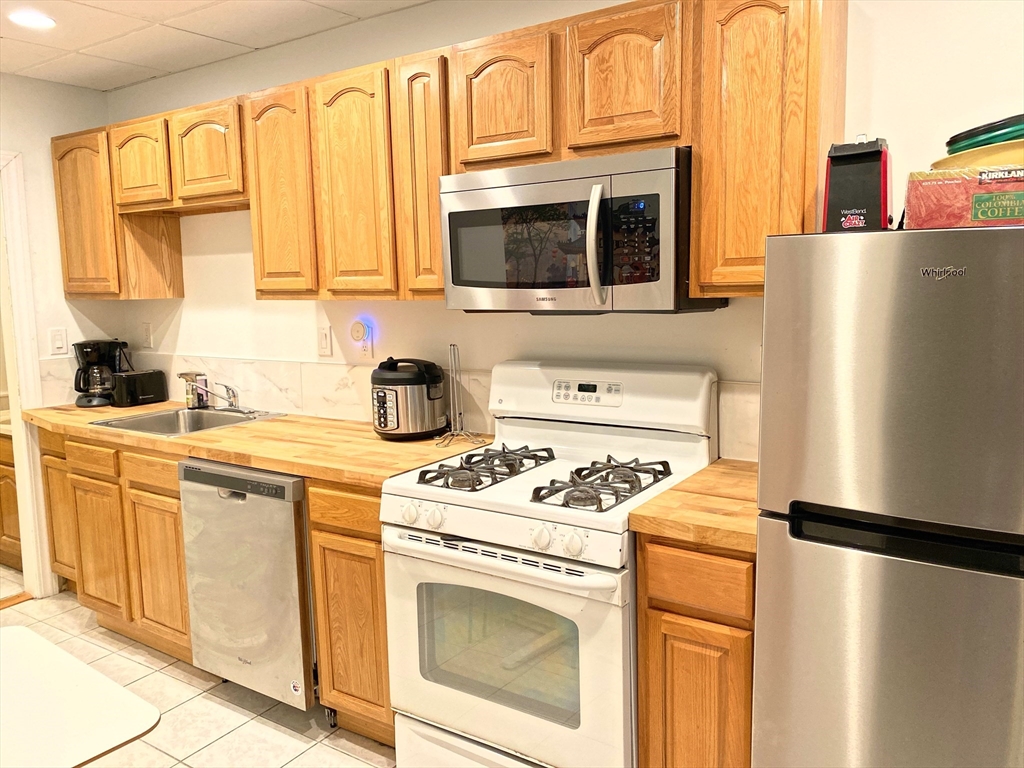 130 West 8th Street, Unit 3 Boston, MA 02127 - Photo 24 of 32 a kitchen with stainless steel appliances a refrigerator sink and cabinets