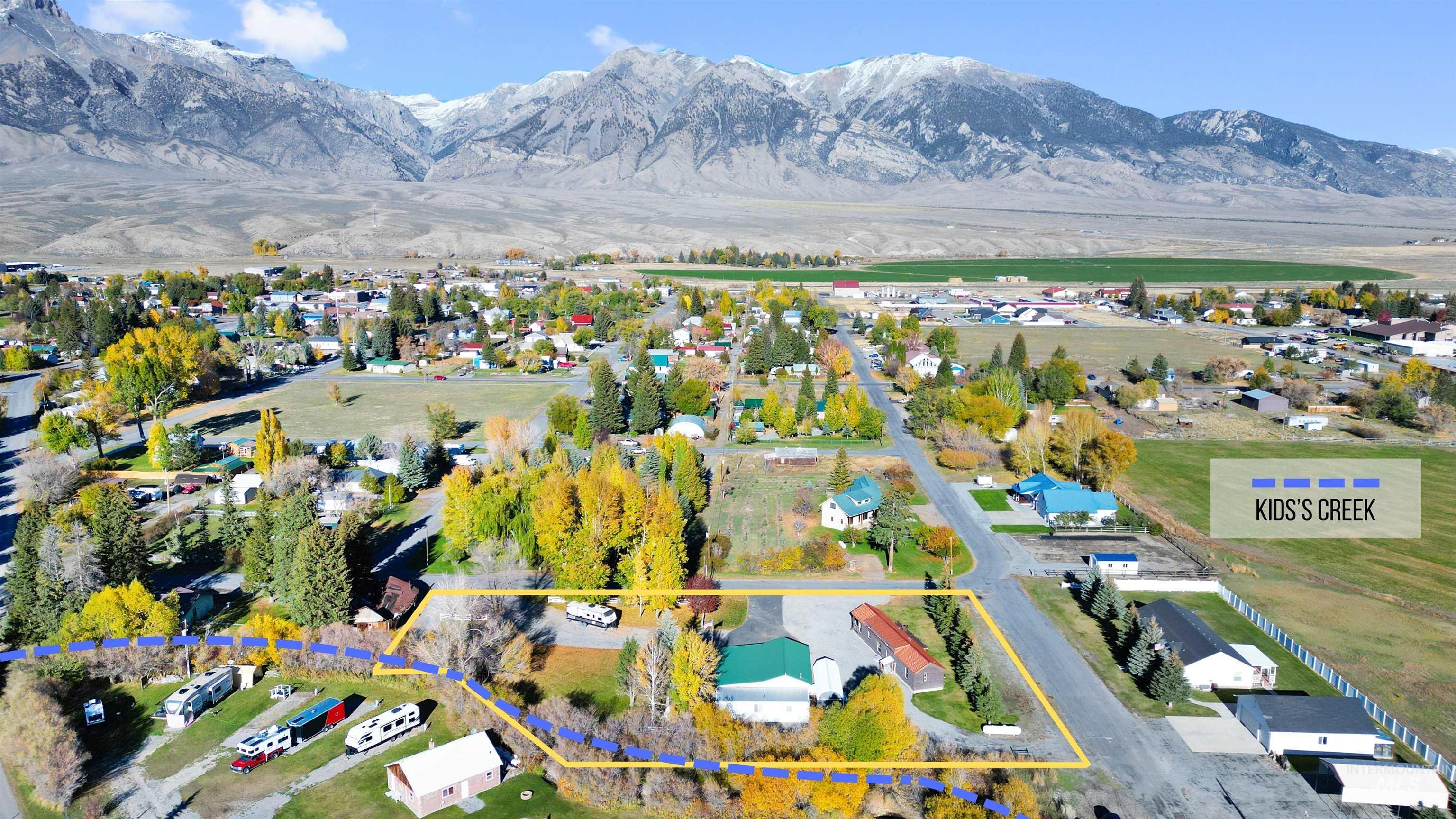 Aerial view of residential area with a mountain backdrop and property parcel outlined