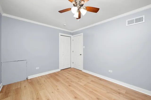 a view of a room with a ceiling fan and wooden floor
