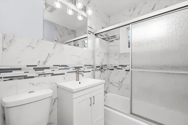 a bathroom with a sink a toilet and shower