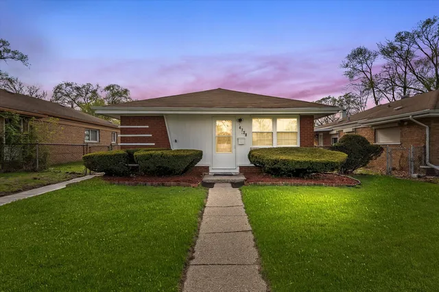 a front view of a house with a garden and trees