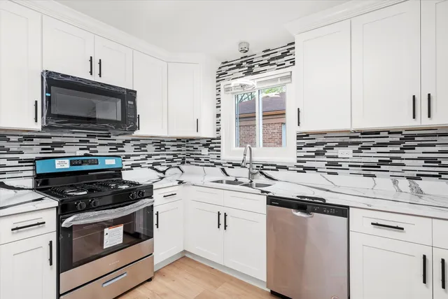 a kitchen with granite countertop a stove sink and microwave