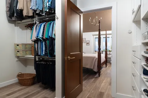 a view of walk in closet with clothes and shoes