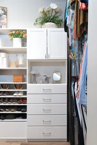 a view of walk in closet with clothes and shoes