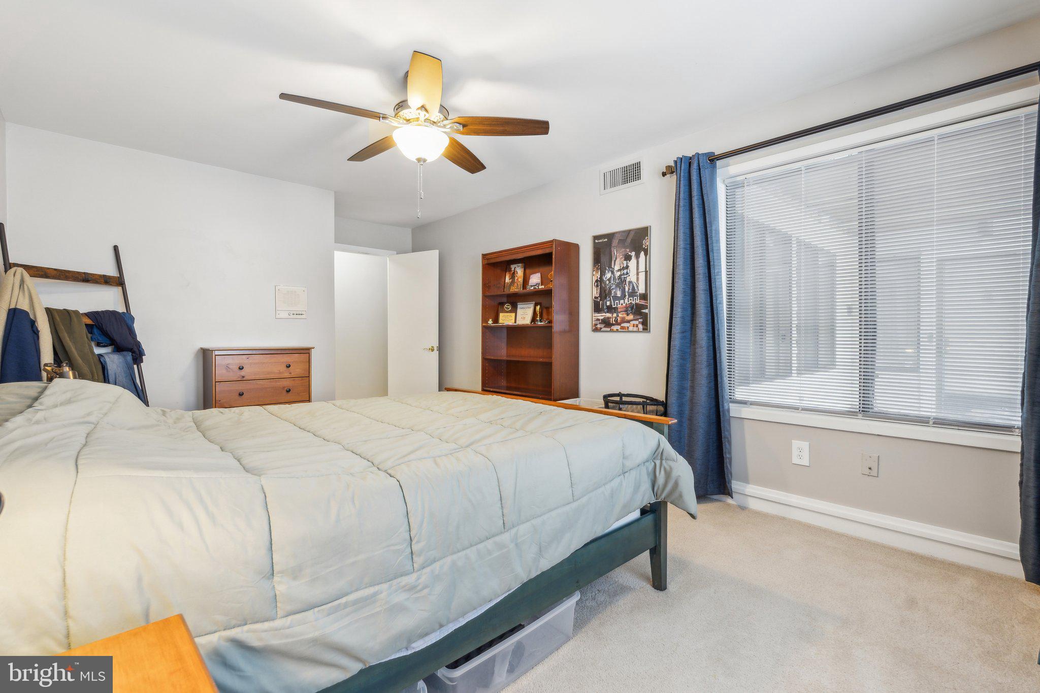 10108 Hellingly Place, Unit 300 Gaithersburg, MD 20886 - Photo 8 of 22 a bedroom with a large bed and a chandelier