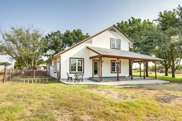 a front view of house with yard outdoor seating and barbeque oven