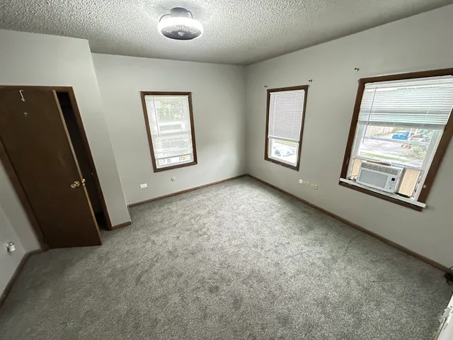 a view of an empty room with window and mirror