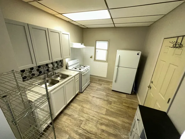 a kitchen with sink a refrigerator and cabinets