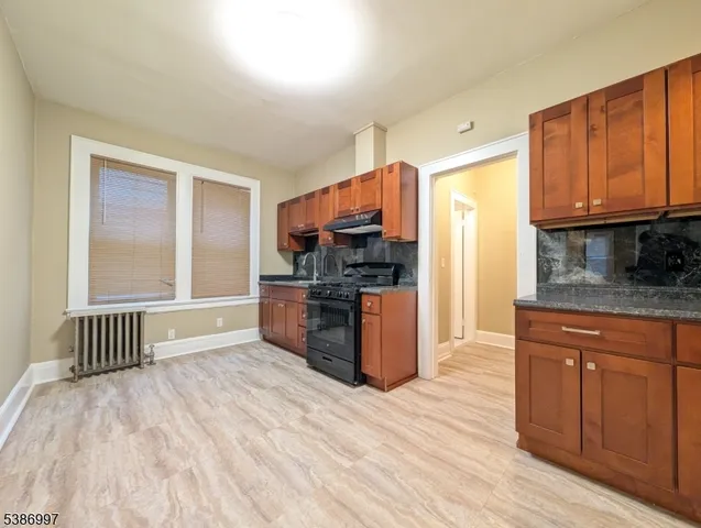 a kitchen with stainless steel appliances granite countertop a stove a sink dishwasher a refrigerator and cabinets with wooden floor