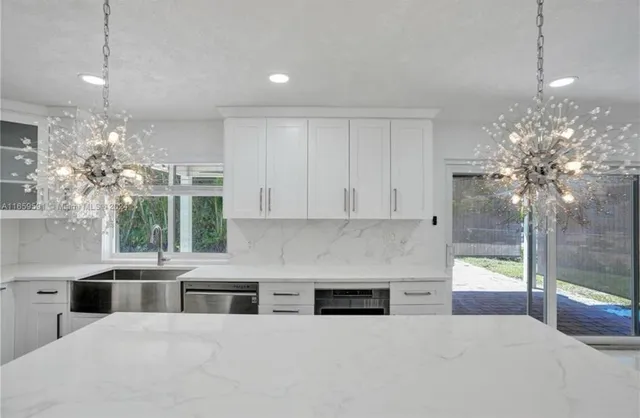 a kitchen with granite countertop a stove a sink a refrigerator and a granite counter tops