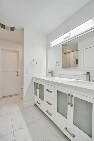 a spacious bathroom with a granite countertop sink and a mirror