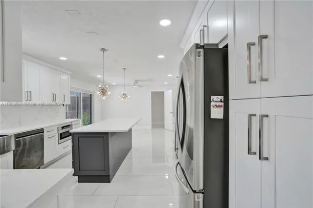 a kitchen with white cabinets and appliances
