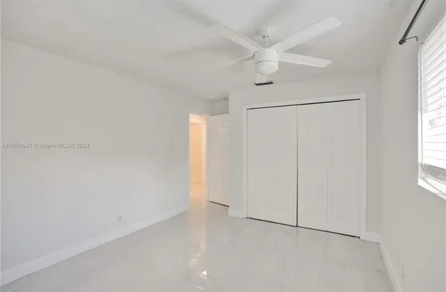 an empty room with windows and closet