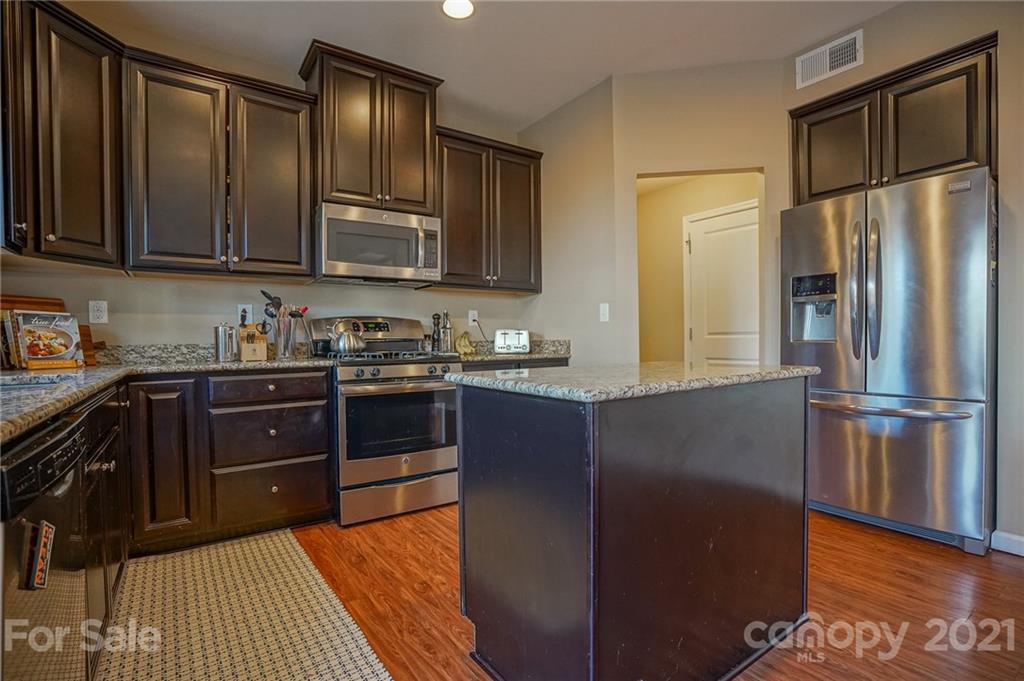 285 Almora Loop Mooresville, NC 28115 - Photo 12 of 45 a kitchen with stainless steel appliances granite countertop a refrigerator stove top oven and sink