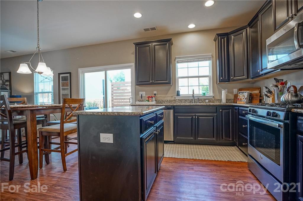 285 Almora Loop Mooresville, NC 28115 - Photo 14 of 45 a kitchen with granite countertop a sink stove and cabinets