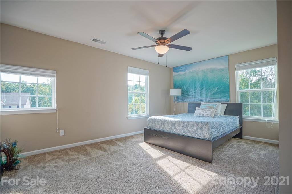 285 Almora Loop Mooresville, NC 28115 - Photo 24 of 45 a spacious bedroom with a large bed and a window