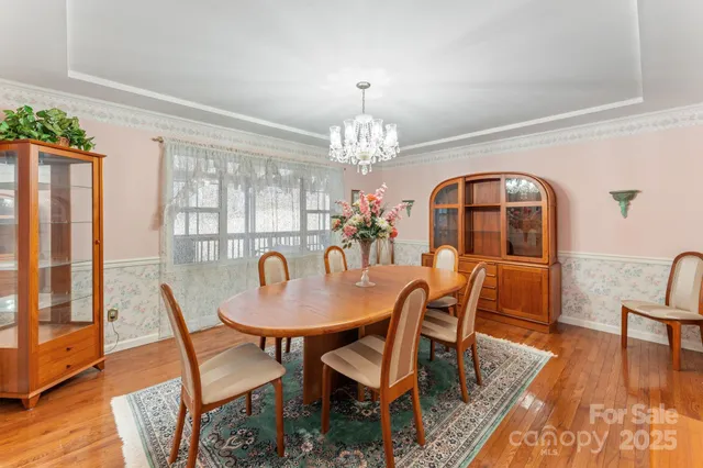 a dining room with furniture a chandelier and wooden floor