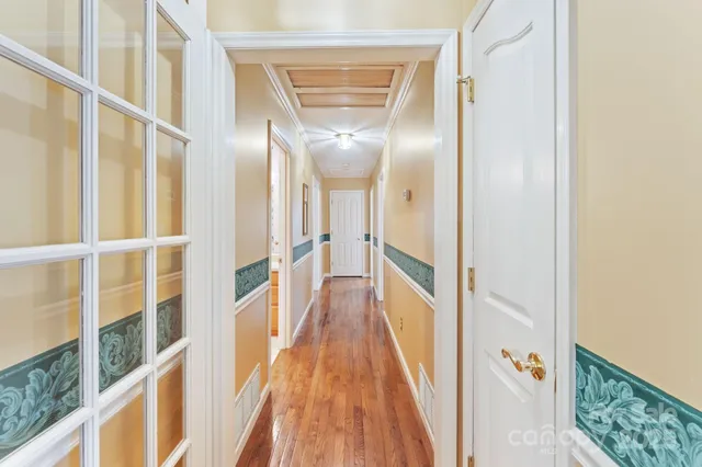 a view of a hallway with wooden floor and staircase