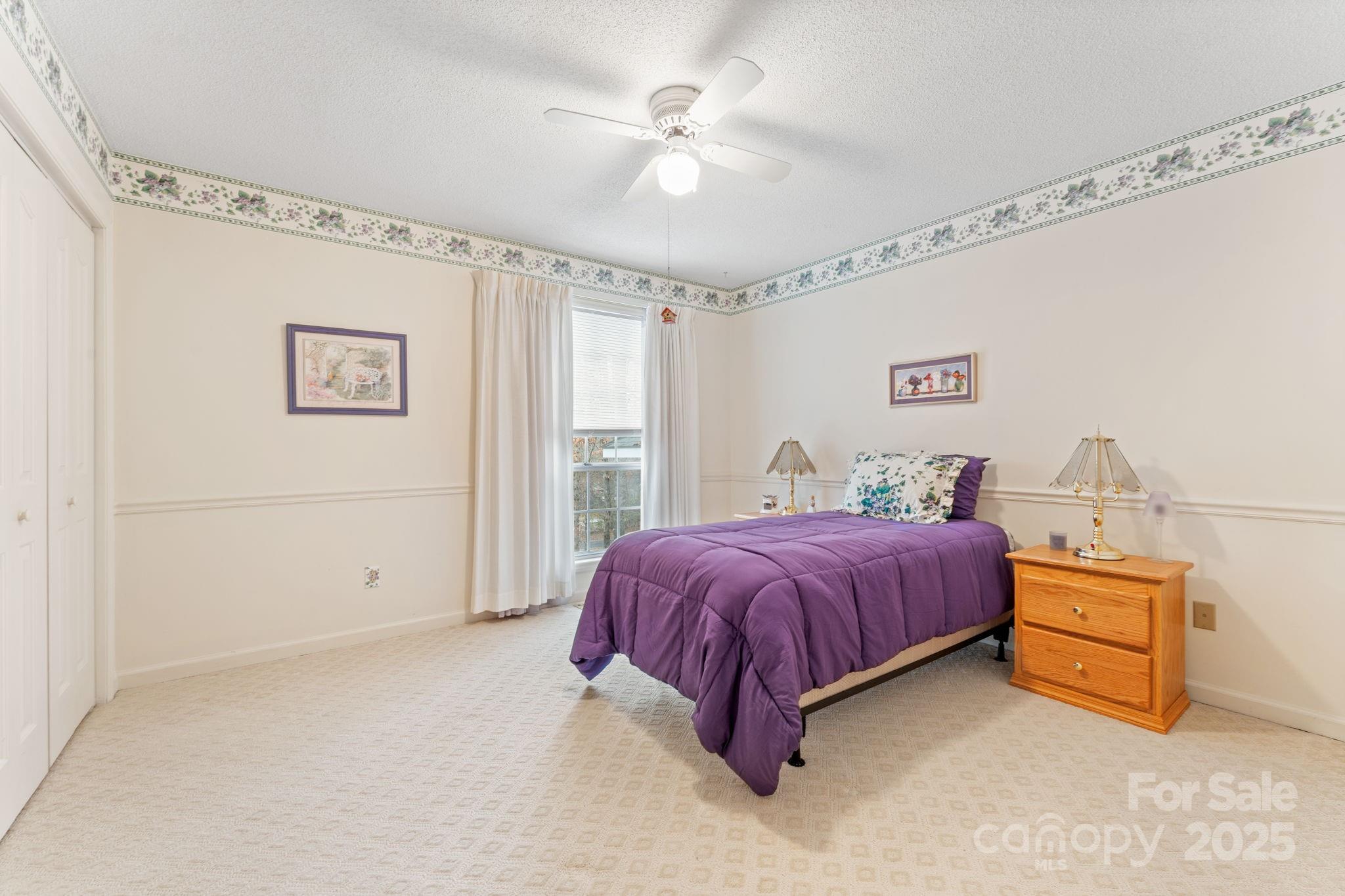 184 Trimont Mountain Road Franklin, NC 28734 - Photo 17 of 41 a spacious bedroom with a bed and a chandelier