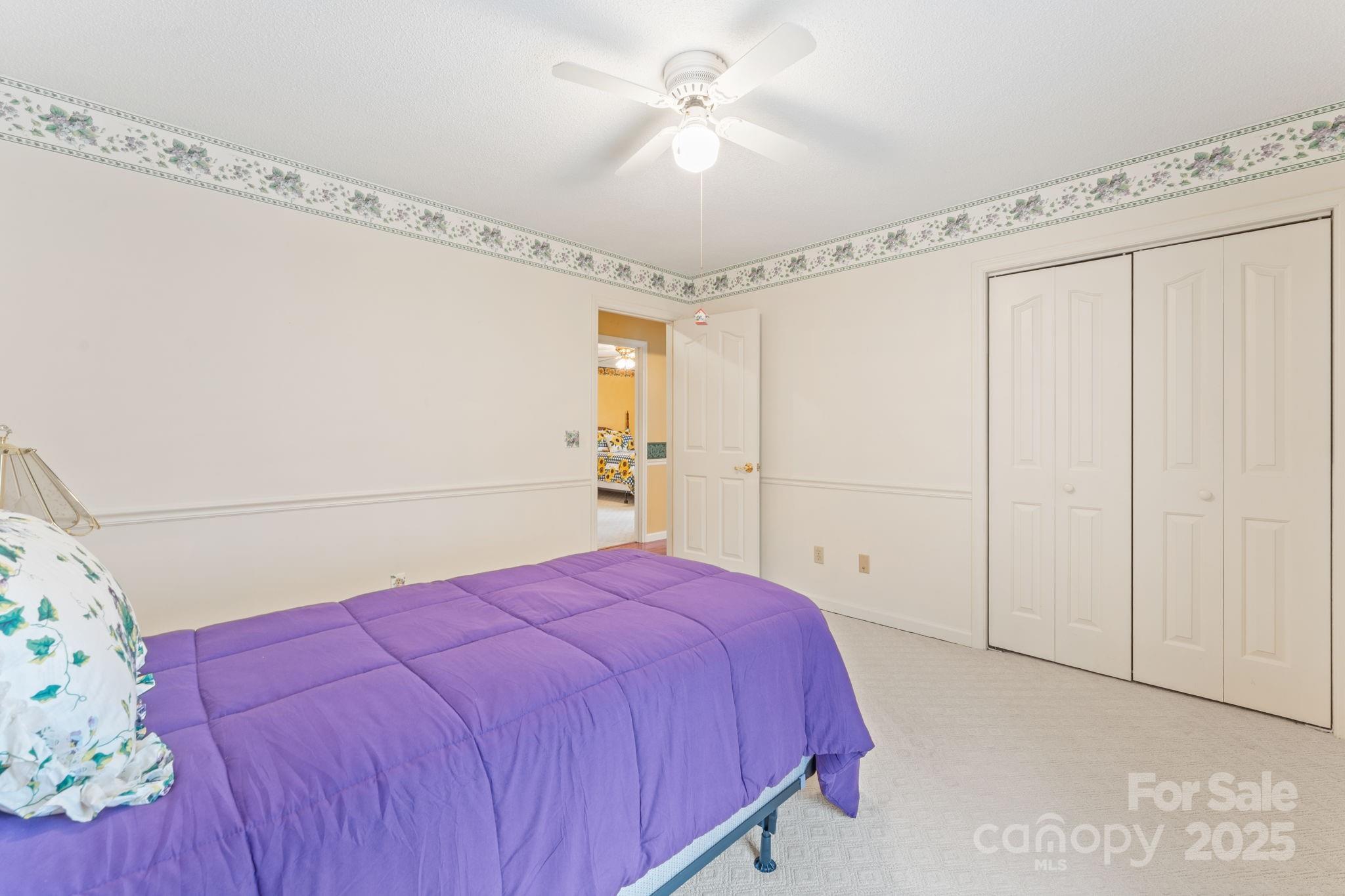 184 Trimont Mountain Road Franklin, NC 28734 - Photo 18 of 41 a spacious bedroom with a bed and a chandelier fan