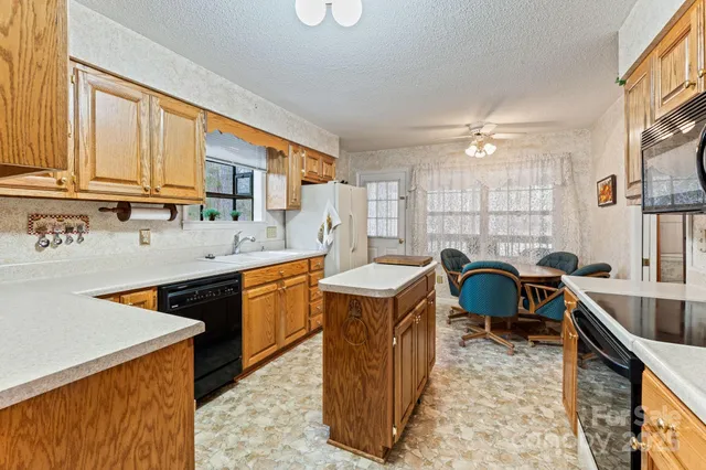 a kitchen filled a sink a counter and a dining table