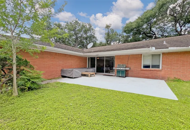 a view of a house with backyard and sitting area