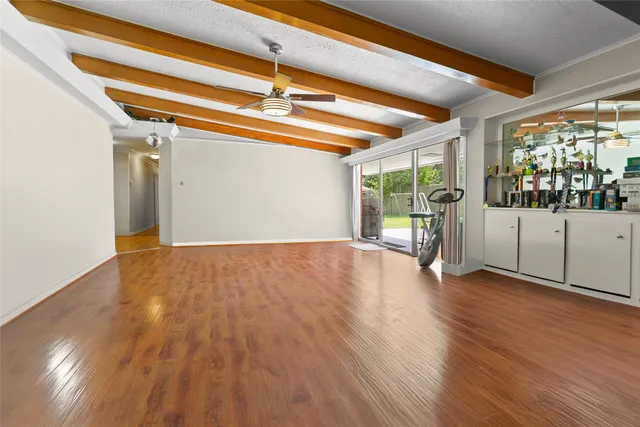 a view of a room with wooden floor and a ceiling fan